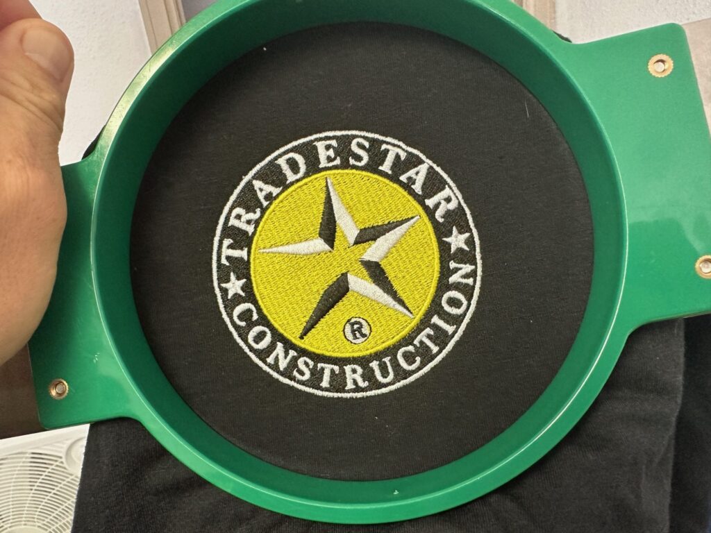 Custom logo for a business still on the hoop at the embroidery shop