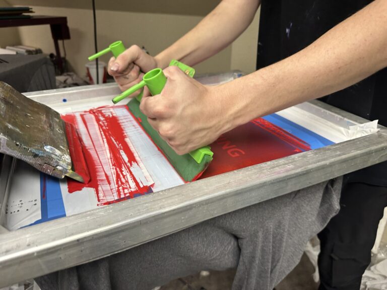 Screen printing a custom t-shirt at The Print Plug in Nampa