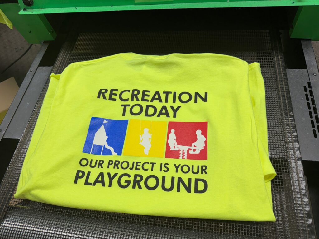 Custom t-shirts in safety green at The Print Plug screen printing shop in Nampa, Idaho