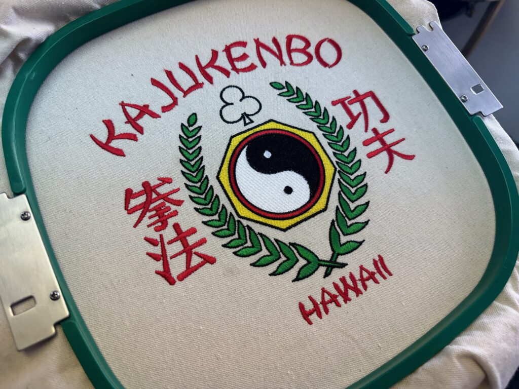 Custom embroidered design still on the hoop at The Print Plug embroidery shop in Nampa