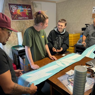 The Print Plug team looking at a large format wall decal in Nampa