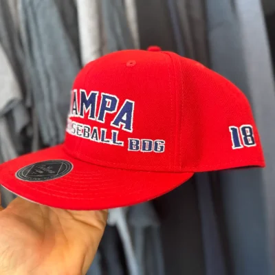 Red custom embroidered baseball hat with side placement