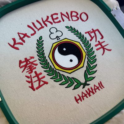 Custom embroidered design still on the hoop at The Print Plug embroidery shop in Nampa