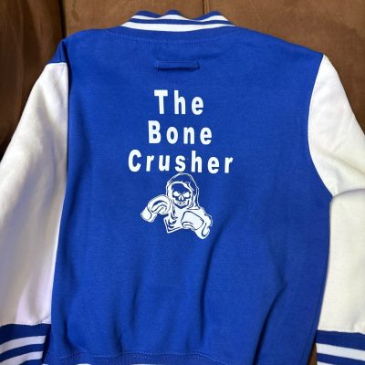 Custom HTV print on the back of a letterman jacket for a young kid at The Print Plug in Nampa