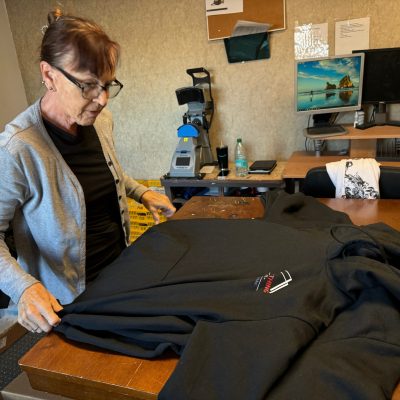 Print Plug team mate performing quality check on custom t-shirts