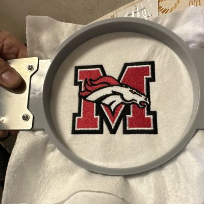 Red and black embroidered logo for a local school jacket / uniform